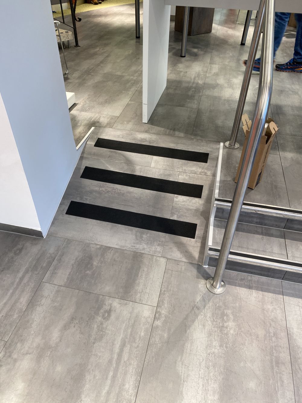 Treppe mit integrierter Rollstuhlrampe im Sanitätshaus, gestaltet von Bäuerlein Objektdesign.