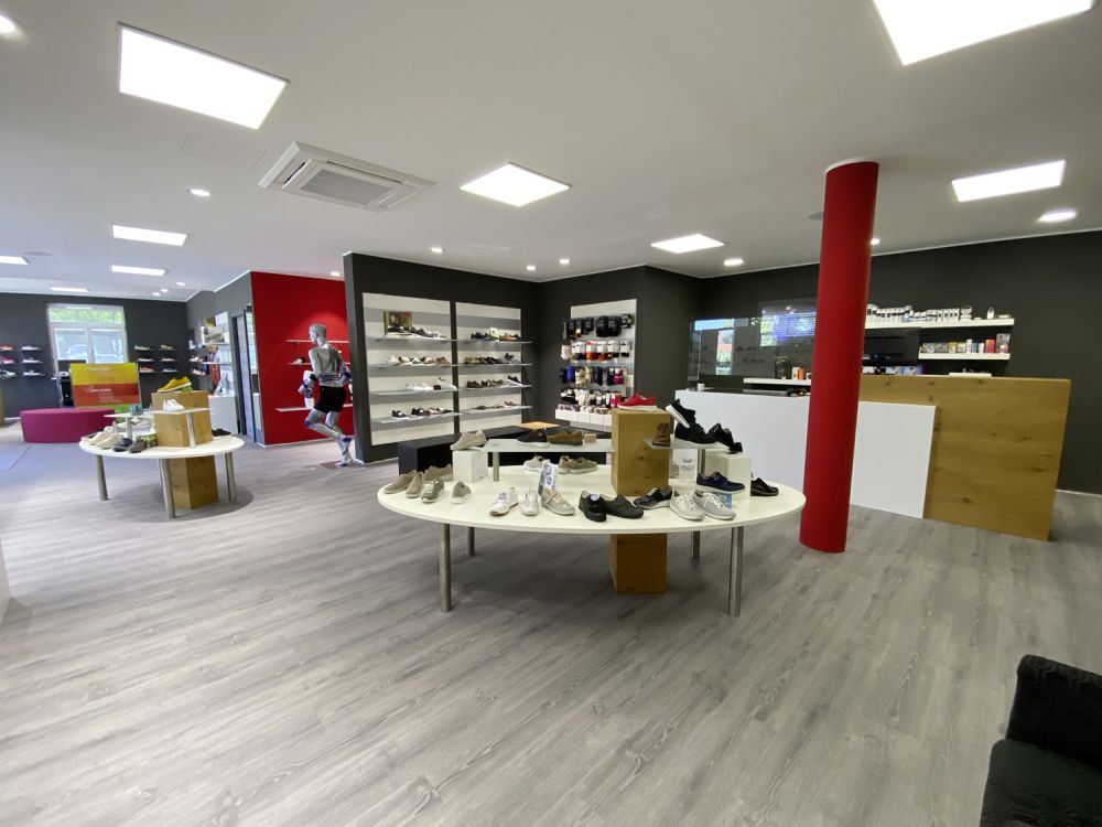 Großzügiger Verkaufsraum mit klar strukturierter Präsentationsfläche. Integrierte Sitz- und Anprobemöglichkeiten bieten Komfort und laden zur individuellen Beratung ein.