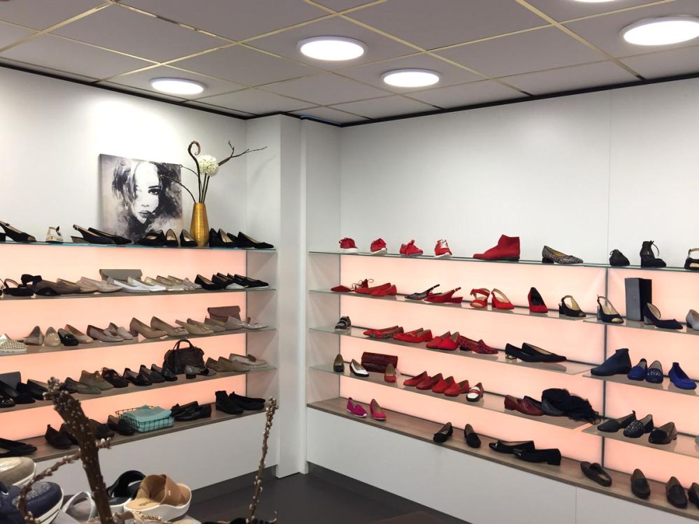 Beleuchtete Schuhregale im exklusiven Ladenausbau